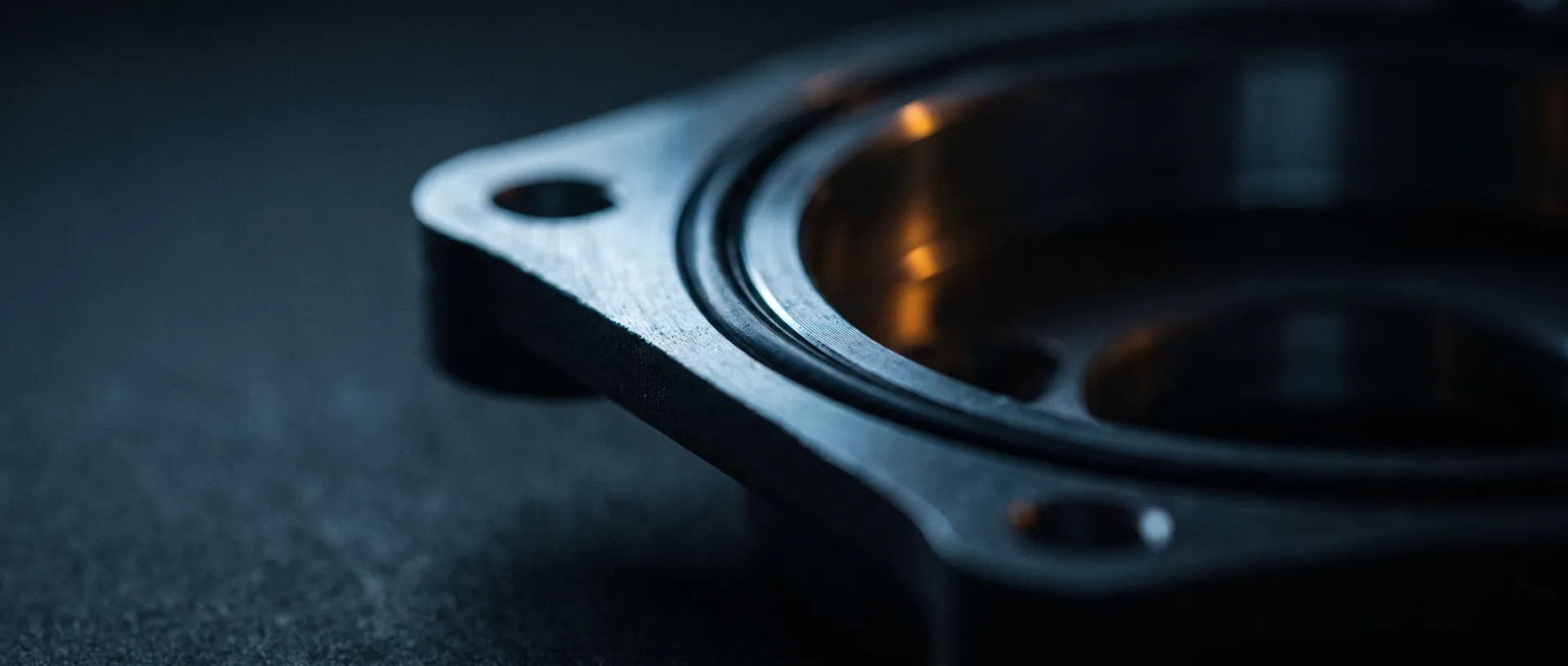 Extreme macro of a machined gasket sealing face with an O-ring groove on a die-cast aluminum housing, raking light