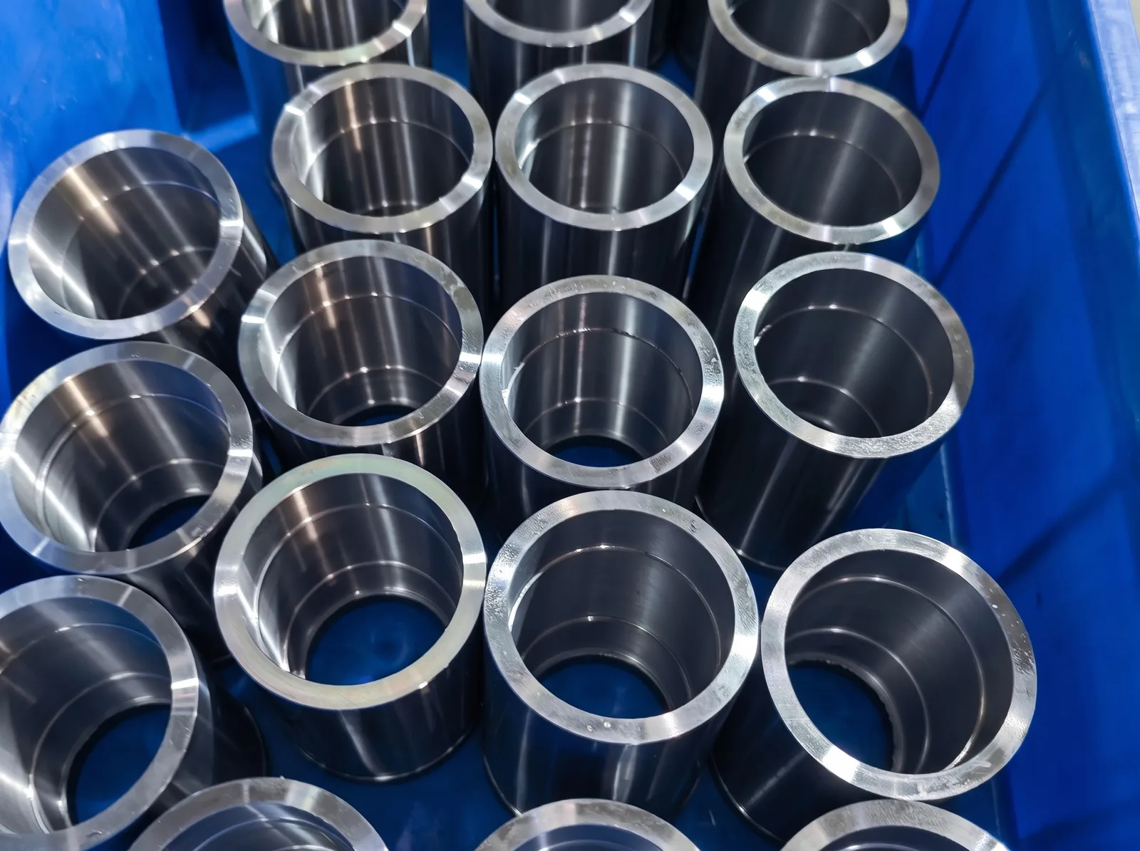 A crate of CNC-turned steel sleeves
