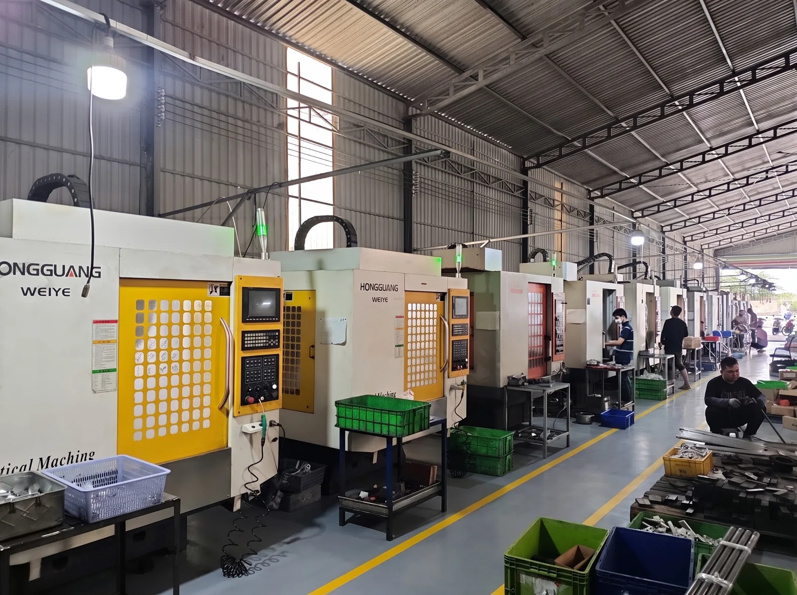A row of vertical machining centers with parts crates